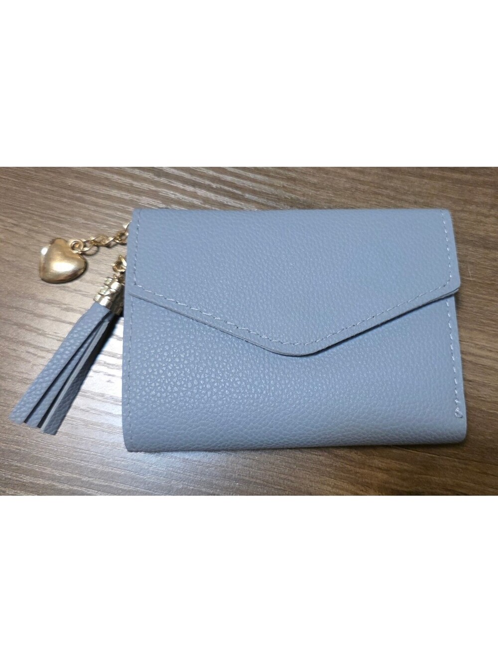 Light blue pebbled faux leather bifold wallet with tassel charm